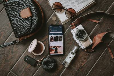  Reiseausrüstung mit Fotokamera, Mobilephone, Autoschlüssel und Buch. 